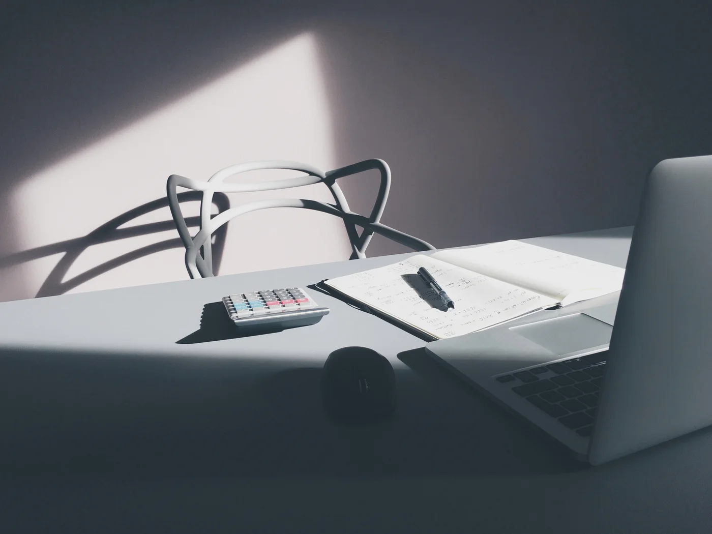 Historical desk photograph with laptop, notebook and calculator; not a customer invoice or payment record